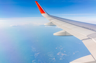 View from the airplane window at a beautiful cloudy sky and the airplane wing