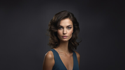Fototapeta premium Captivating portrait of a young, radiant beauty. Brunette model with flawless skin and natural makeup, gazing confidently at the camera. Studio shot with copy space