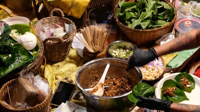 Making Miang Kham (traditional Southeast Asian herbal snack from Thailand and Laos), Traditional Thai snack. It&rsquo;s a snack containing different ingredients of herbs and vegetables. It helps balance the