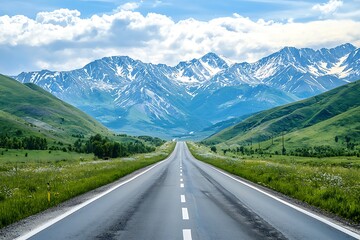 Naklejka premium A winding paved road through a lush green valley with snow-capped mountains in the background.