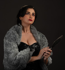 A beautiful lady dressed in retro look against a dark background.