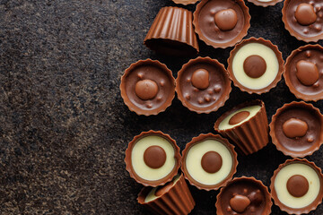 Sweet pralines. Chocolate truffles on black table. Top view.
