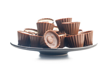 Sweet pralines. Chocolate truffles on plate isolated on white background.