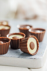 Sweet pralines. Chocolate truffles on cutting board on white table.