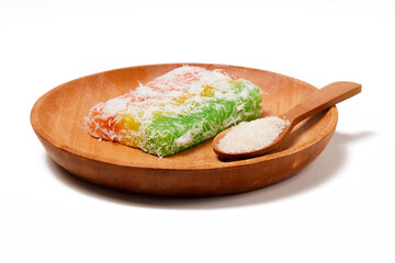 Sentiling, or Lapis Singkong, is a sweet Indonesian snack made from cassava, colored red, yellow, and green. Served with grated coconut or sugar. Photographed on a white background.