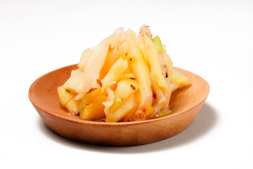 Mango sambal made from shredded young sour mango, mixed with chili, sugar, and spices. A blend of spicy, sweet, and tangy flavors. Photographed on a white background.