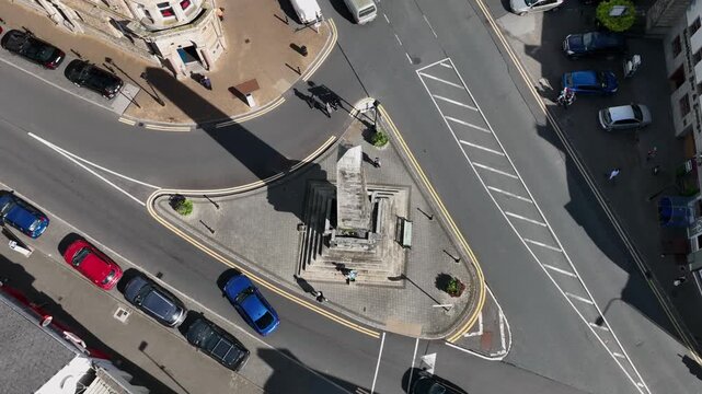 Monaghan Town, County Monaghan, Ireland, September 2022. Drone in Bird's Eye view rotates and tilts up from the Dawson Monument to establish Chuch Square at midday with cars and people roaming.