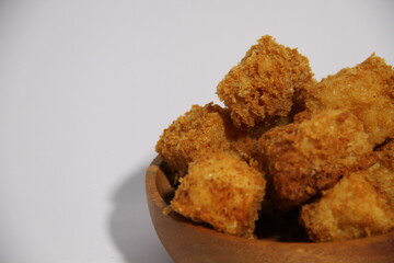 Crispy fried tofu in a wooden bowl, ready to eat.