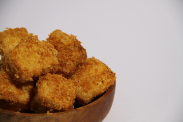 Crispy fried tofu in a wooden bowl, ready to eat.