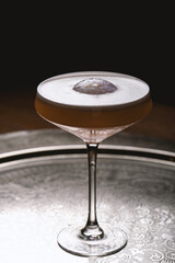 Cocktail in a martini glass on a dark background.