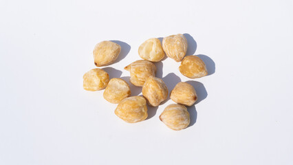 Candlenut Seeds, Casting Shadows on a White Surface, Emphasizing Their Organic Form