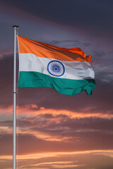 Indian Flag at Sunset: The vibrant Indian tricolor flutters proudly against a dramatic sunset sky, symbolizing national pride and the spirit of India. 