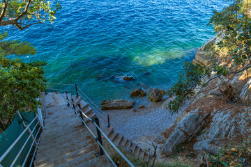 Dangerous descent down steep stairs to a small beach