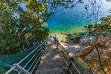 Dangerous descent down steep stairs to a small beach