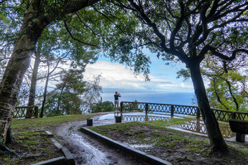 A person stands at a lookout point on the coast of Biscay province of Spain, gazing at an expansive...