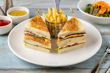 Chicken club sandwich with fries, ketchup, mustard and mayonnaise