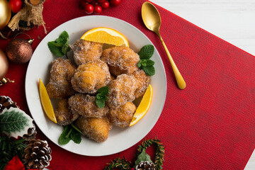 Delicious traditional Spanish fritters. Table decorated with Christmas decorations.