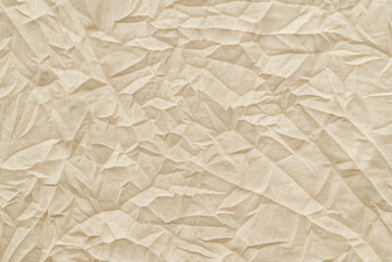 Fototapeta premium Old textile, crumpled texture, surface for background. Pale brown recycled battered kraft material, copy space for text