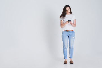 Texting, online and woman with cellphone, studio and chat in space, reading and notification of social media app. Typing, communication and message, student and person with mobile in white background