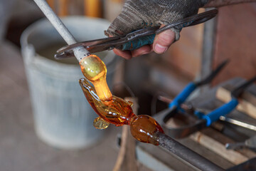Stemmer adds another gather of melting glass to the ball.