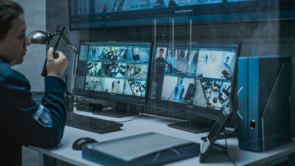 Multiple monitors and big digital screen showing surveillance video footage. Female dispatch or CCTV operator works on computer in monitoring center with security cameras, talks by walkie talkie.