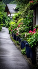 A charming summer day in Germany with dark blue trash cans lined up against a backdrop of lush gardens and an old wooden house