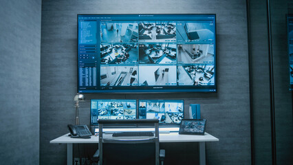 Computer monitors, tablet display and big digital screen showing surveillance video footage from...