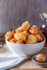 Curd donuts with sugar served with tea or coffee on a light wooden background. Rustic style.