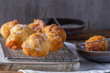 Curd donuts with sugar served with tea or coffee on a light wooden background. Rustic style.