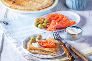 Pancakes with gravlax, cottage cheese and olives. A traditional dish for Maslenitsa or Carnival.