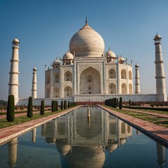 Naklejka premium Taj Mahal, India: The stunning white marble Taj Mahal glowing softly under a clear blue sky, with its lush gardens and reflecting pool.