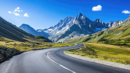 Fototapeta premium Scenic mountain road with curves and turns, set against a backdrop of towering peaks and clear skies. Ideal for travel content
