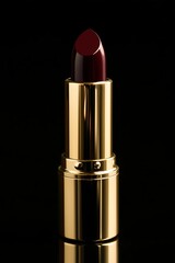 luxurious dark red lipstick in an elegant gold tube, standing against a black background