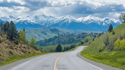Winding road along a mountain ridge with snow-capped peaks in the distance. Great for outdoor and nature content