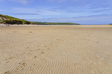 Footprints lead down the rippled sands of Crantock beach.