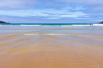 Uncrowded Crantock beach in Cornwall on a bright sunny summer morning.