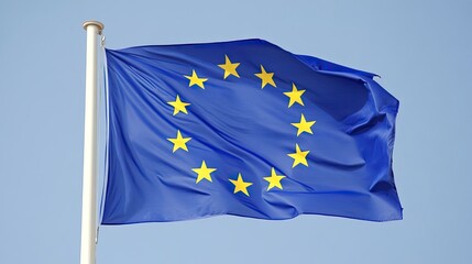 The EU flag waves gracefully, its blue background and yellow stars standing out vividly against a clear sky.