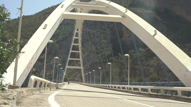 Motorcycle rider through bridge in a sunny day