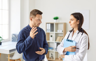 Female doctor or nurse provides care and advice to a male patient during a hospital visit. The consultation reflects the importance of medical aid and professional healthcare services in patient care.