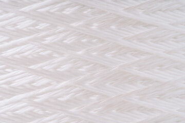 Close-up view of tightly woven fiberglass threads. The intricate pattern showcases the texture and craftsmanship of the material.