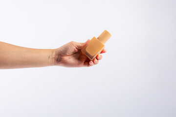Cosmetic cream tube in womans hand on white background 