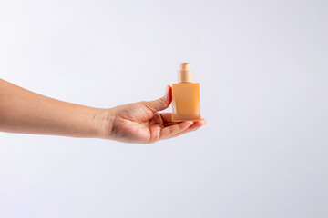 Cosmetic cream tube in womans hand on white background 