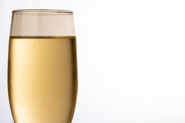 A close-up of a champagne glass filled with champagne on a white backdrop, symbolizing the joy of holiday celebrations like Christmas and New Year's Eve.
