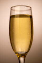 A close-up vertical shot of a frosted champagne glass against a gold gradient background. The image captures the essence of celebration, making it ideal for New Year's and holiday festivities.