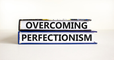 Overcoming perfectionism symbol. Concept words Overcoming perfectionism on beautiful books. Beautiful white paper background. Business Overcoming perfectionism concept. Copy space.