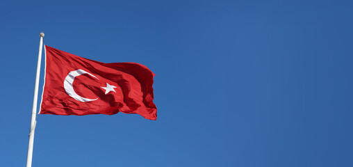 Turkish flag waving in the blue sky.