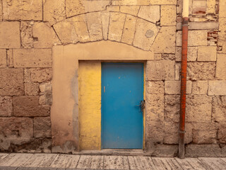 Puerta bicolor en una pared de piedra