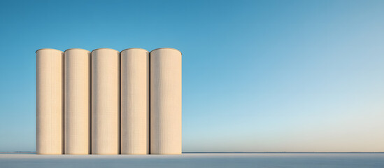 Large industrial silos standing in a rural setting with clear blue skies