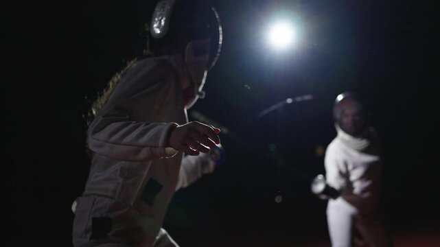 Two Women Practicing Fencing, Ladies In Uniform And Fencing Helmets Waving Foils Or Epees