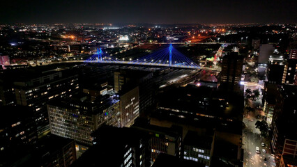 Nelson Mandela Bridge At Johannesburg In Gauteng South Africa. City At Night Landscape. Illuminated Cable Bridge. Johannesburg At Gauteng South Africa. Landmark Buildings. Colored Bridge.